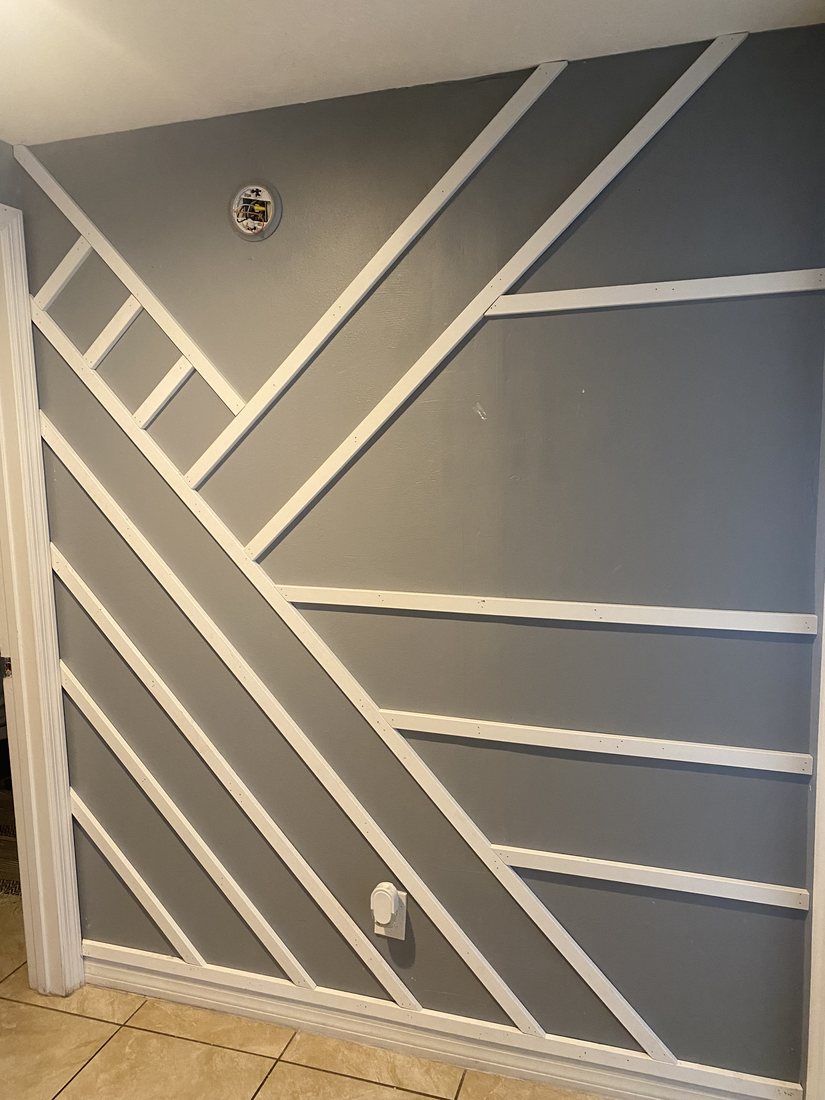 Grey wall with an asymmetrical diagonal molding pattern in white