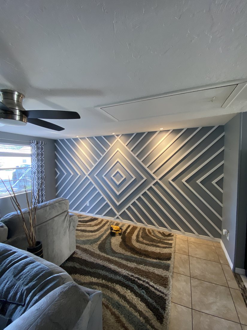 Living room feature wall with a lit herringbone slat pattern