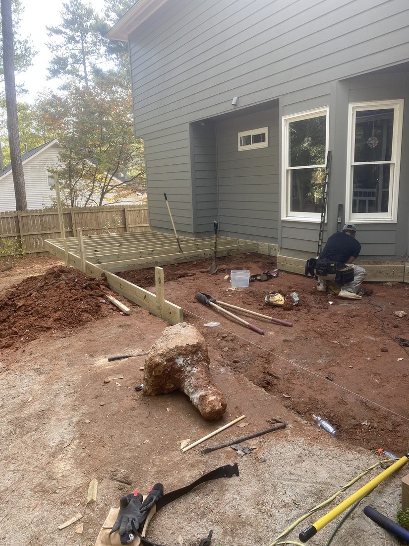 Deck footings being dug and set at the rear of a house