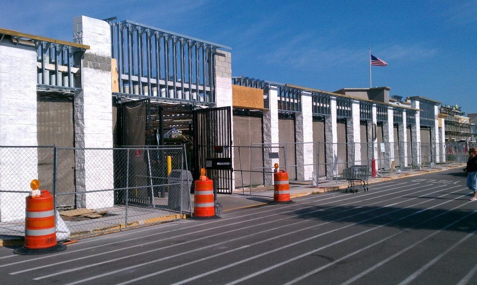 Commercial building under construction with structural framing and storefront openings