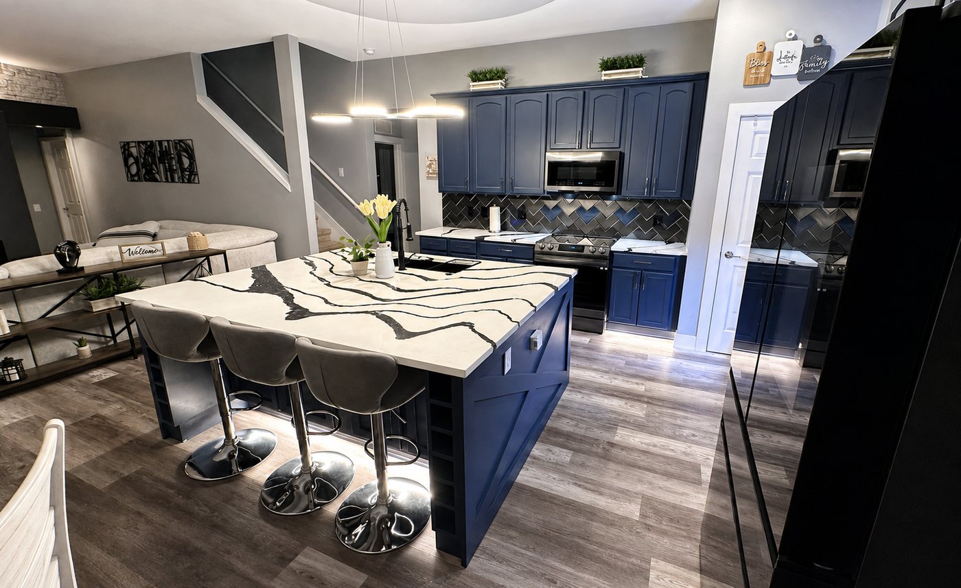 Remodeled kitchen with navy cabinetry, waterfall island, and bar seating
